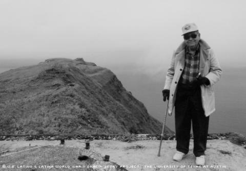 Ramon Martin Rivas stands on top of a concrete bunker in Dutch Harbor, Alaska. The bunker is similar to ones he and other soldiers constructed on the Islands to resist Japanese forces. Rivas returned to Dutch Harbor in 1992 on a vacation.